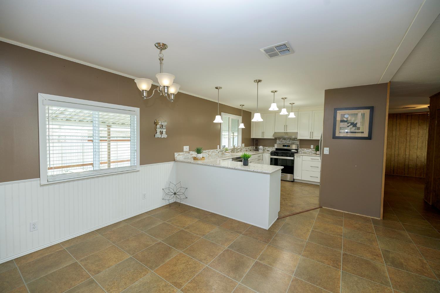 3418 North Waring Road, Unit 24 Denair, CA 95316 - Photo 5 of 48 a view of a kitchen with kitchen island granite countertop a refrigerator a sink dishwasher with a dining table and chairs