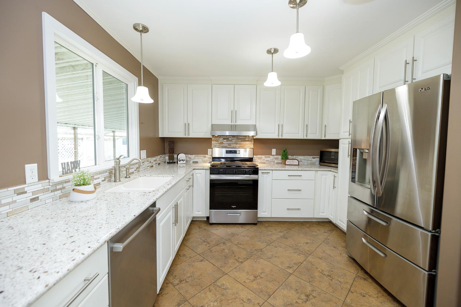 3418 North Waring Road, Unit 24 Denair, CA 95316 - Photo 7 of 48 a kitchen with granite countertop a refrigerator oven a sink and white cabinets