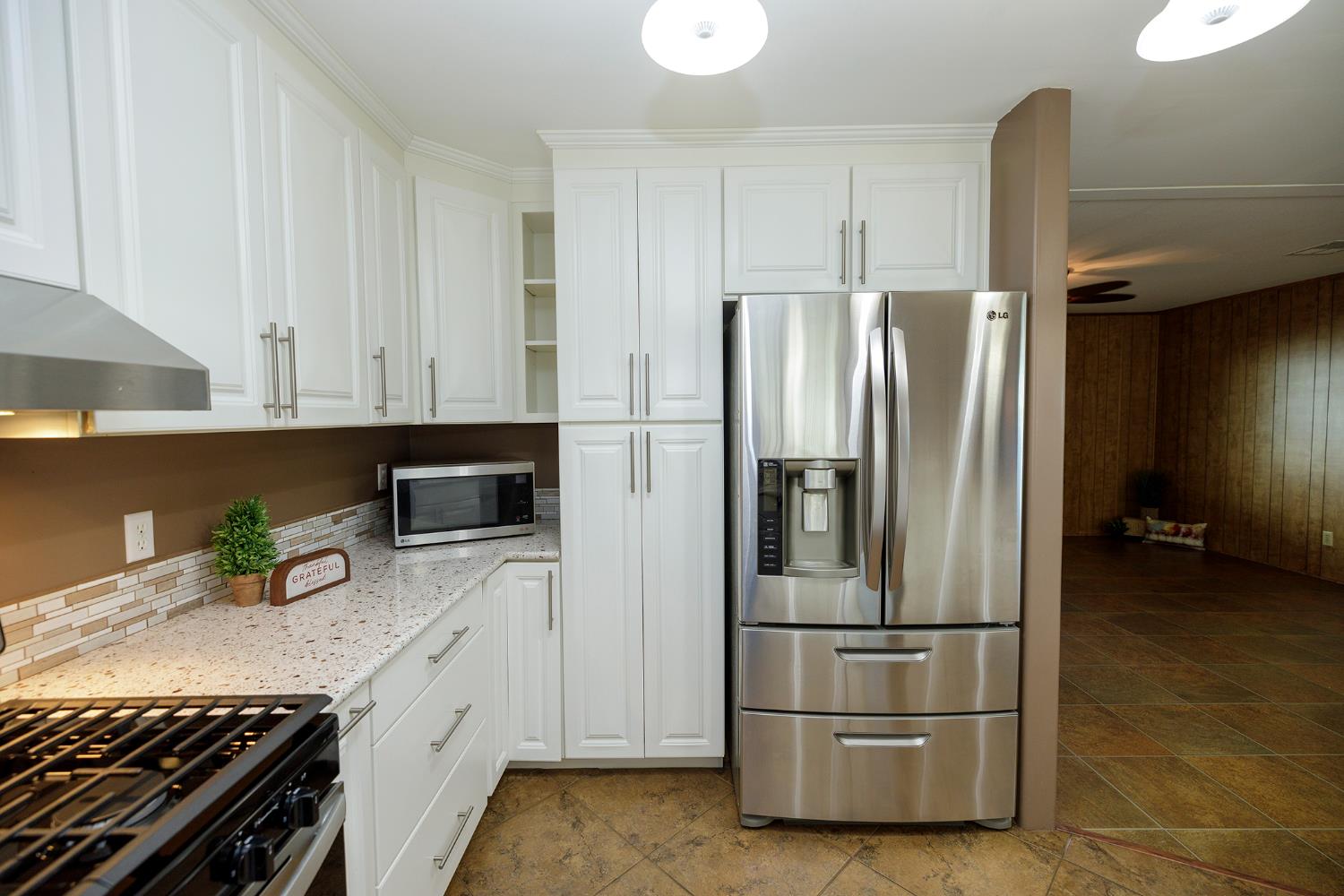 3418 North Waring Road, Unit 24 Denair, CA 95316 - Photo 9 of 48 a kitchen with stainless steel appliances granite countertop a refrigerator and a stove