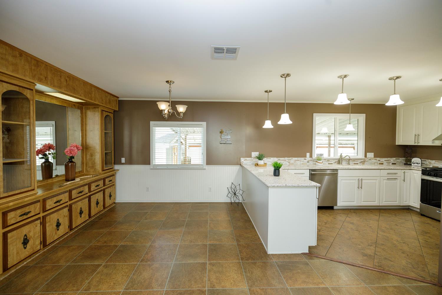 3418 North Waring Road, Unit 24 Denair, CA 95316 - Photo 10 of 48 a large white kitchen with kitchen island a sink a counter space and a window