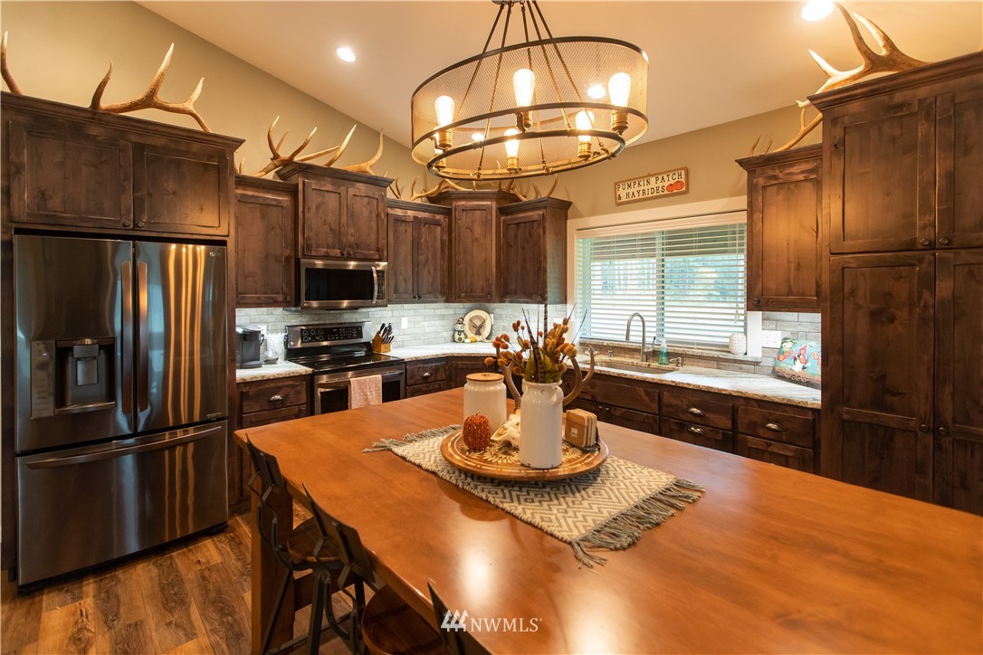 800 Logan Hill Road Chehalis, WA 98532 - Photo 17 of 36 a kitchen with stainless steel appliances a dining table and chairs