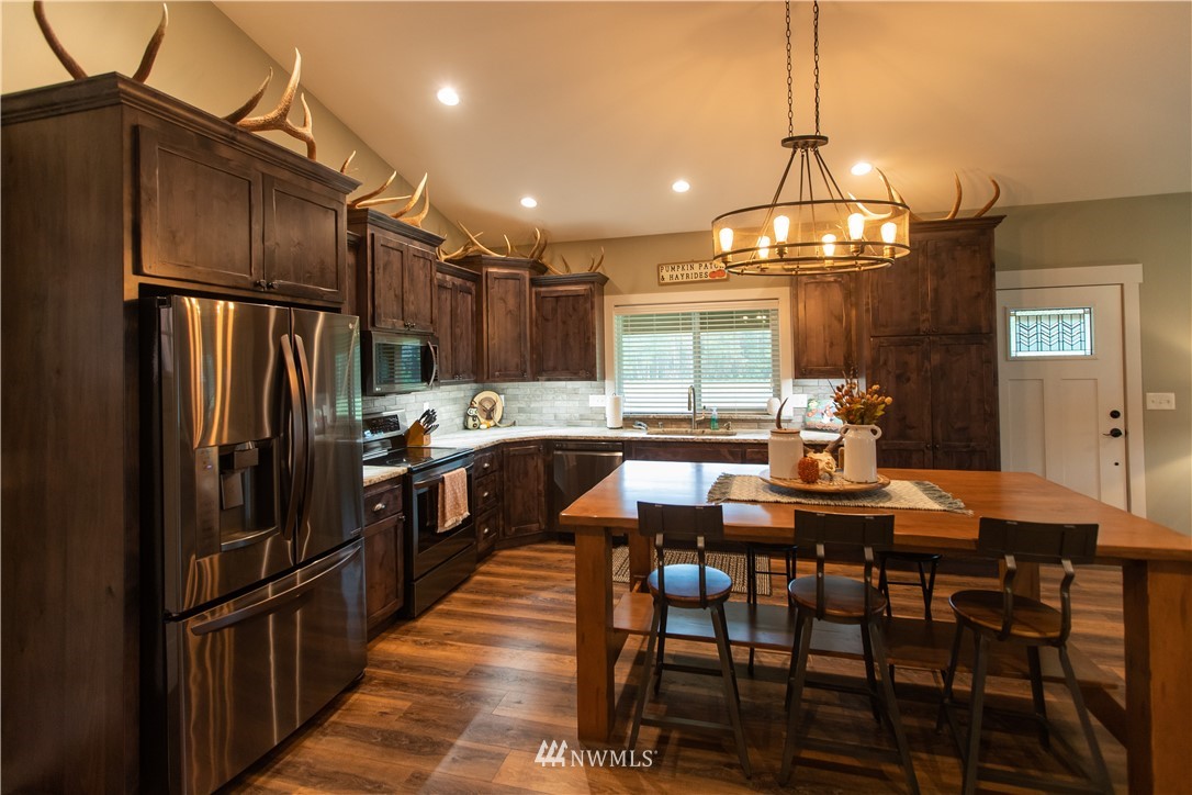800 Logan Hill Road Chehalis, WA 98532 - Photo 18 of 36 a kitchen with stainless steel appliances a dining table chairs and stove