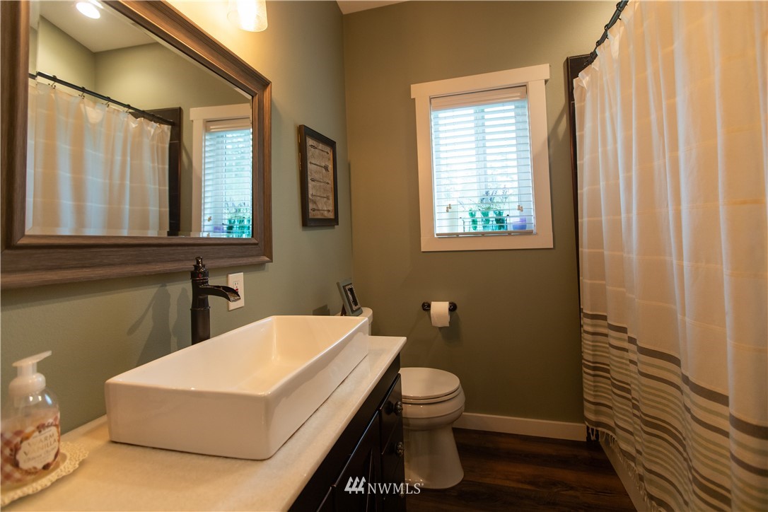 800 Logan Hill Road Chehalis, WA 98532 - Photo 26 of 36 a bathroom with a toilet a sink and a window