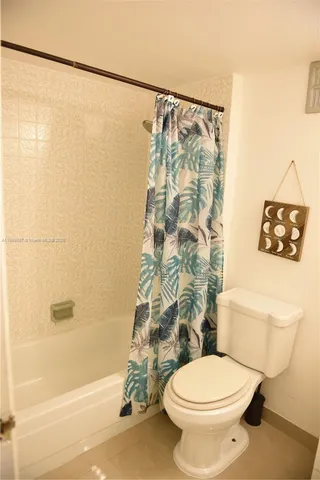 a bathroom with a toilet and a shower curtain