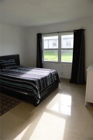 a bed sitting in a bedroom next to a window