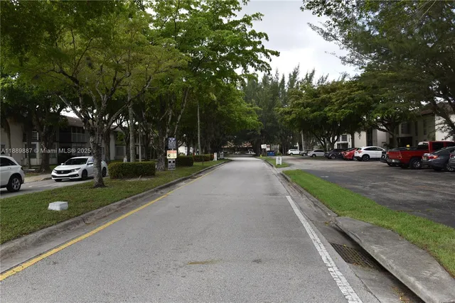 a white bench sitting in a yard with large trees