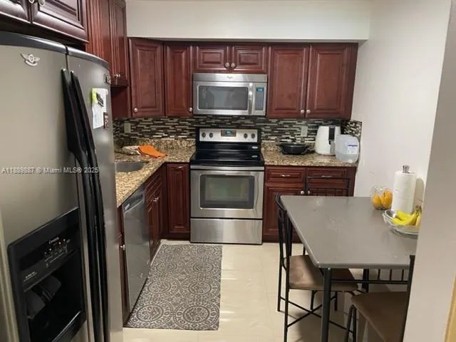 a kitchen with granite countertop a stove microwave and sink