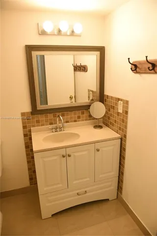 a bathroom with a sink a mirror and vanity