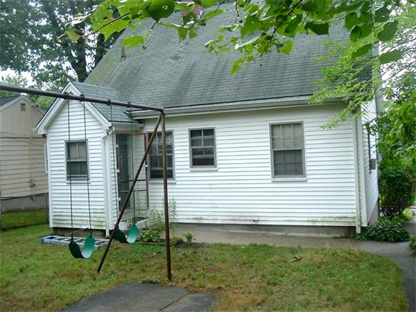 451 Appleton Street Arlington, MA 02476 - Photo 2 of 2 a view of a white house with a yard and lawn chairs under an umbrella