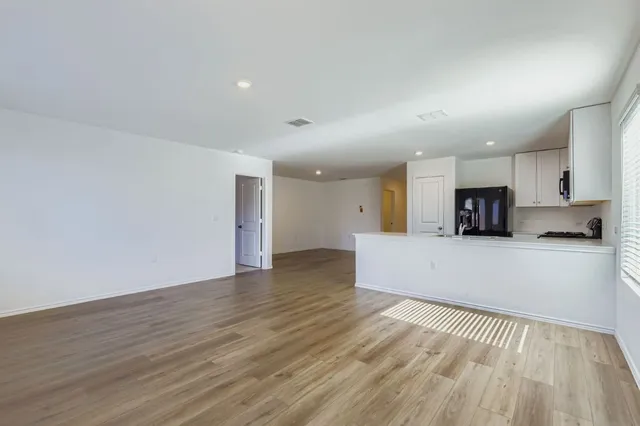 a view of kitchen with kitchen island microwave and wooden floor