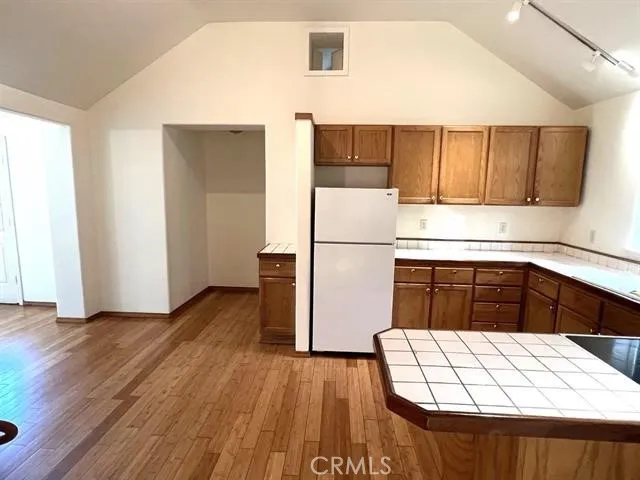 a kitchen with a refrigerator and a stove top oven