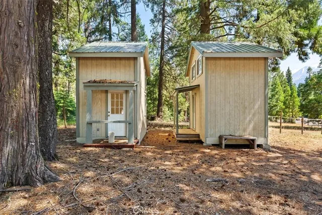 a view of a house with a yard and large tree