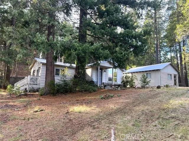 a view of a house with a yard and large tree