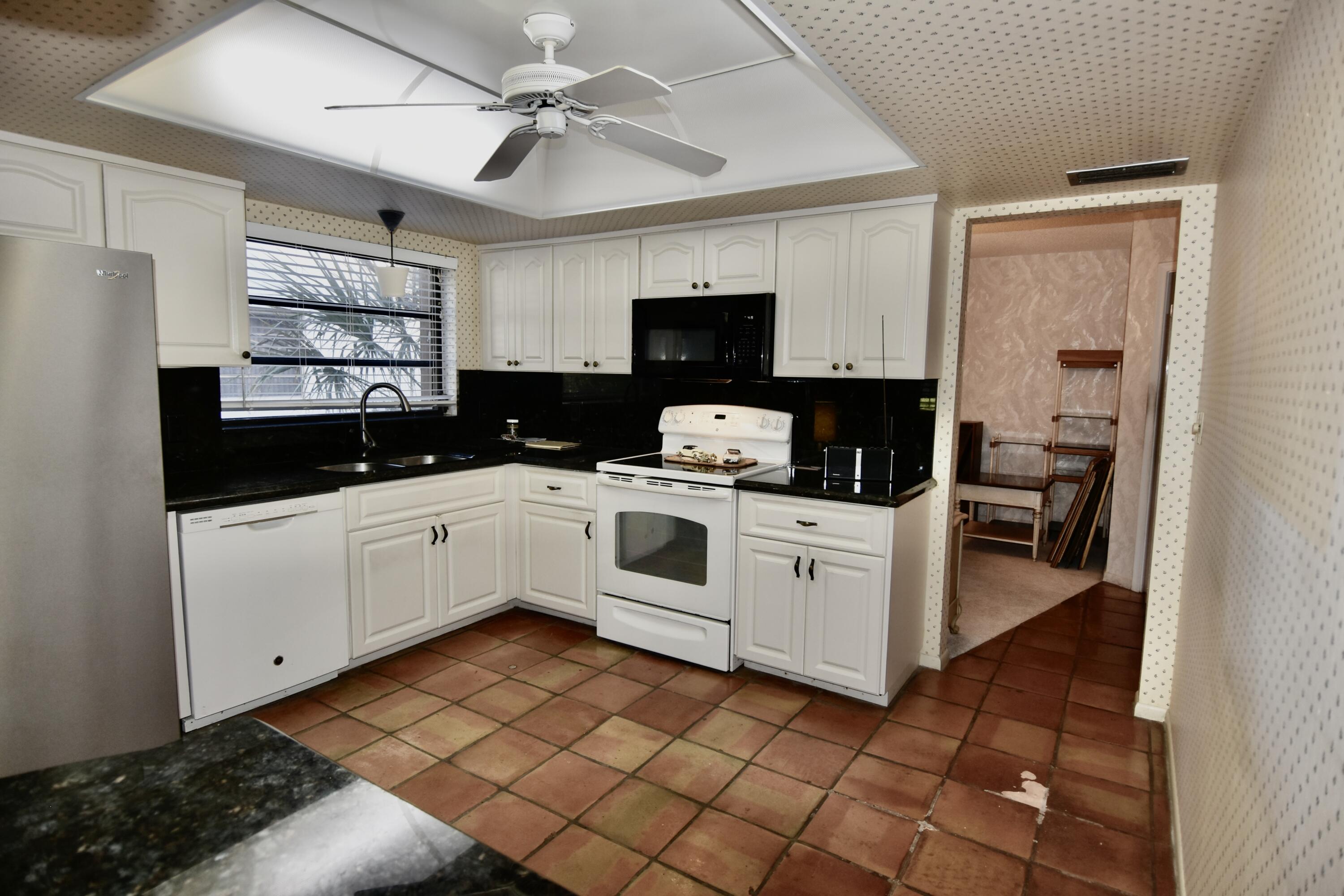 18101 Grove Avenue Boca Raton, FL 33498 - Photo 5 of 12 a kitchen with a white cabinets and white appliances