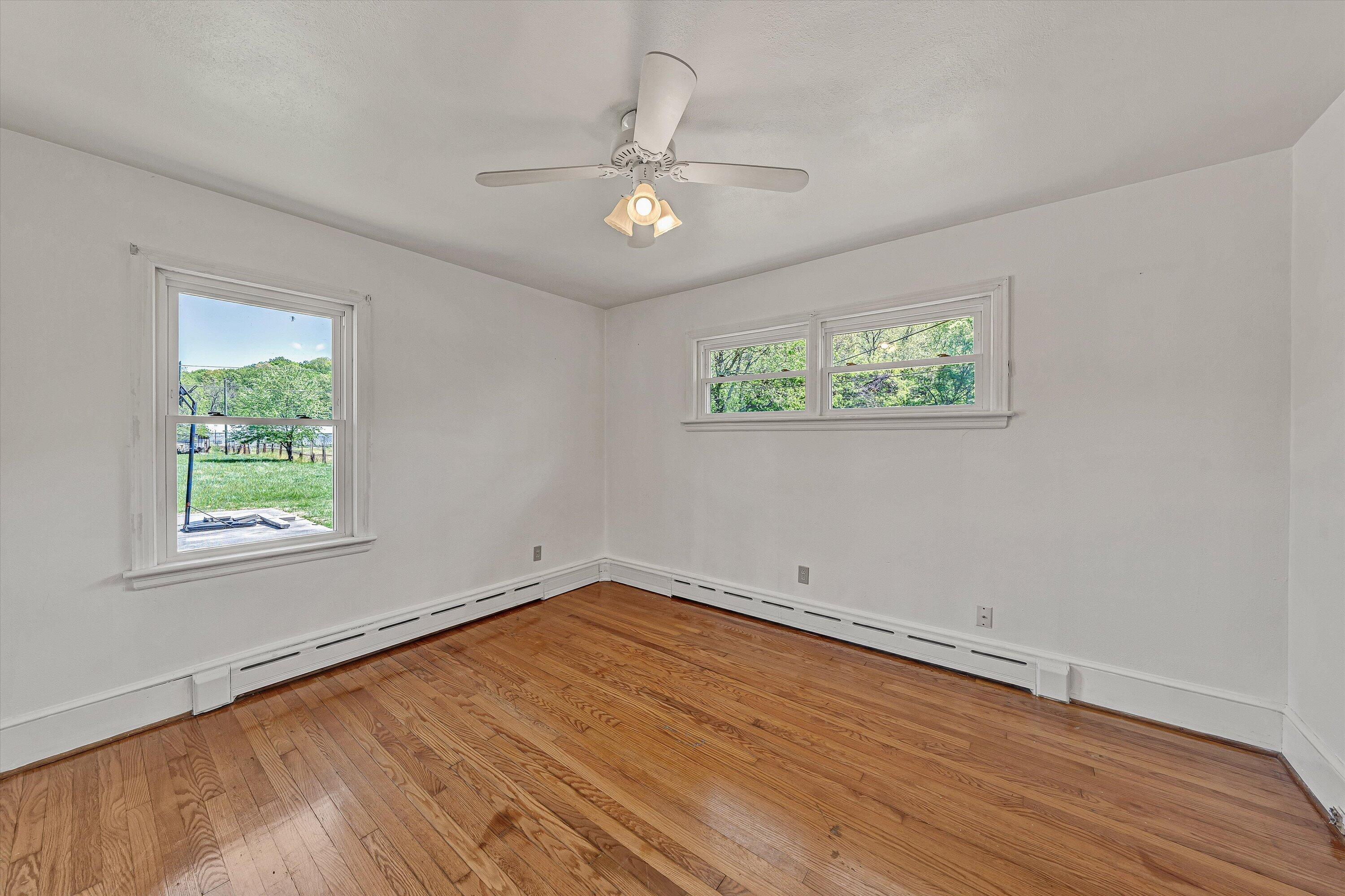 2356 West Riverside Drive Salem, VA 24153 - Photo 13 of 18 an empty room with wooden floor chandelier fan and windows