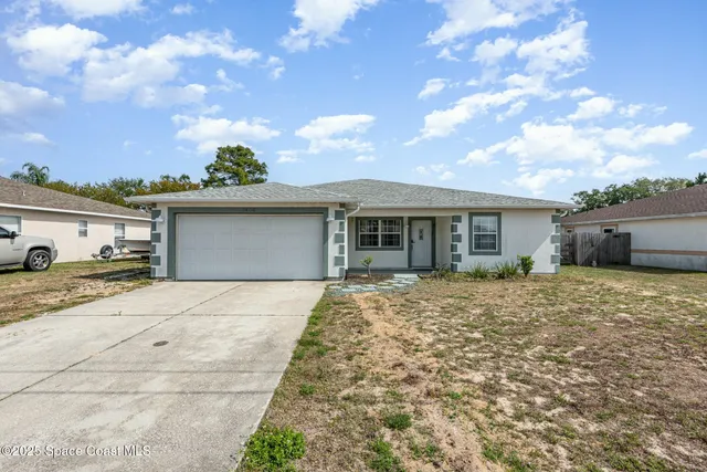 a front view of a house with a garden and yard