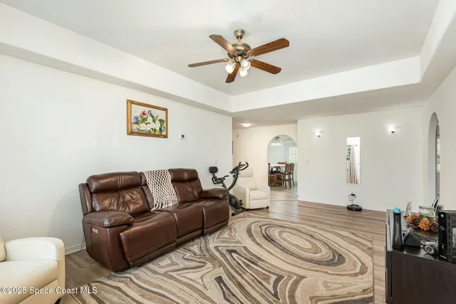 a living room with furniture and a ceiling fan