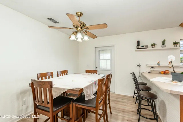 a view of a dining room with furniture and a chandelier fan