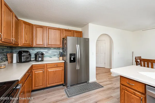 a kitchen with stainless steel appliances granite countertop a refrigerator sink and cabinets