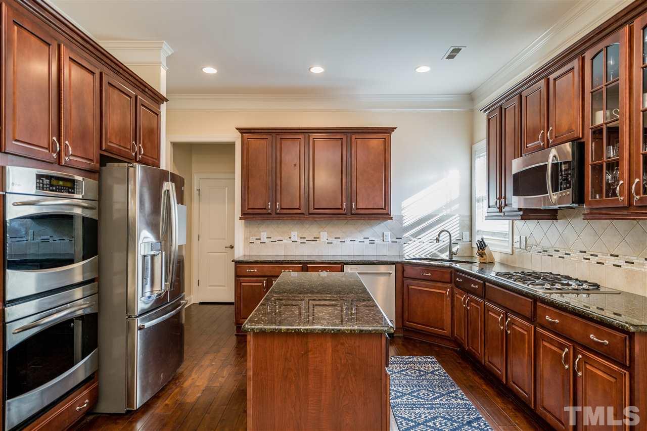 1528 Rodessa Run Raleigh, NC 27607 - Photo 14 of 30 Double ovens, stainless appliances, corner window over the sink, island, glass front cabinet, tile backsplash and recessed lighting make this kitchen a dream for cooking and entertaining.