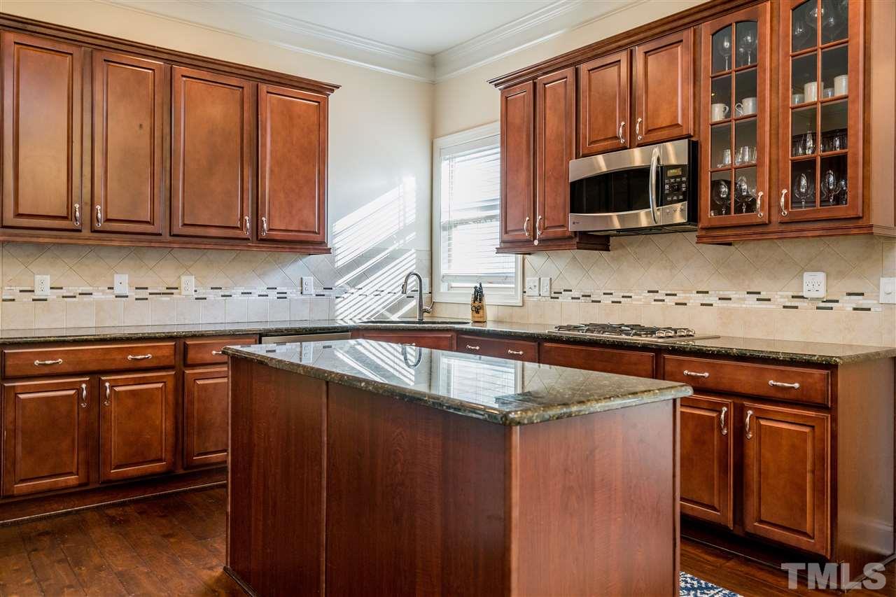 1528 Rodessa Run Raleigh, NC 27607 - Photo 15 of 30 Double ovens, stainless appliances, corner window over the sink, island, glass front cabinet, tile backsplash and recessed lighting make this kitchen a dream for cooking and entertaining.