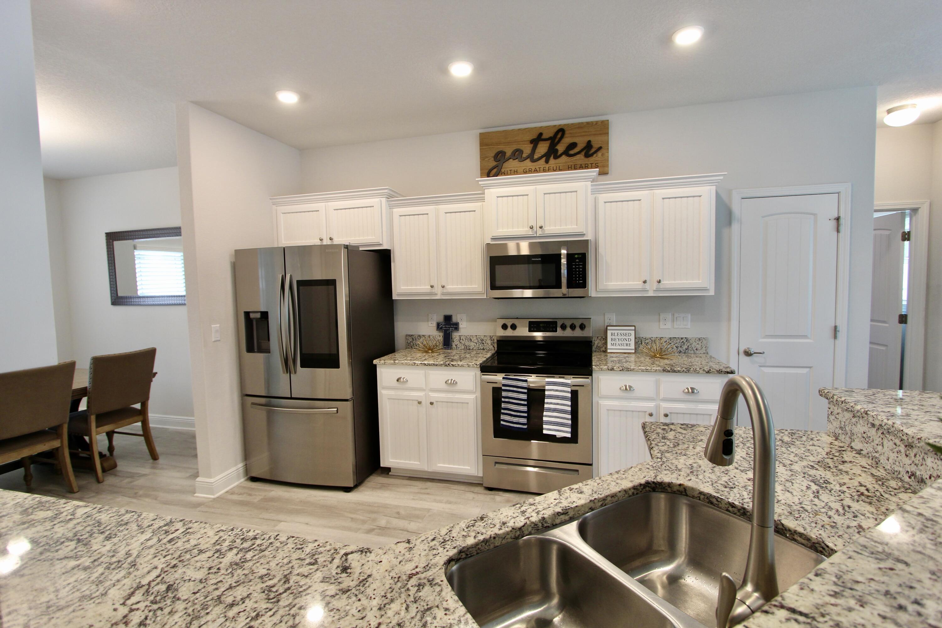 5755 Marigold Loop Crestview, FL 32539 - Photo 18 of 74 a kitchen with granite countertop a refrigerator and a sink