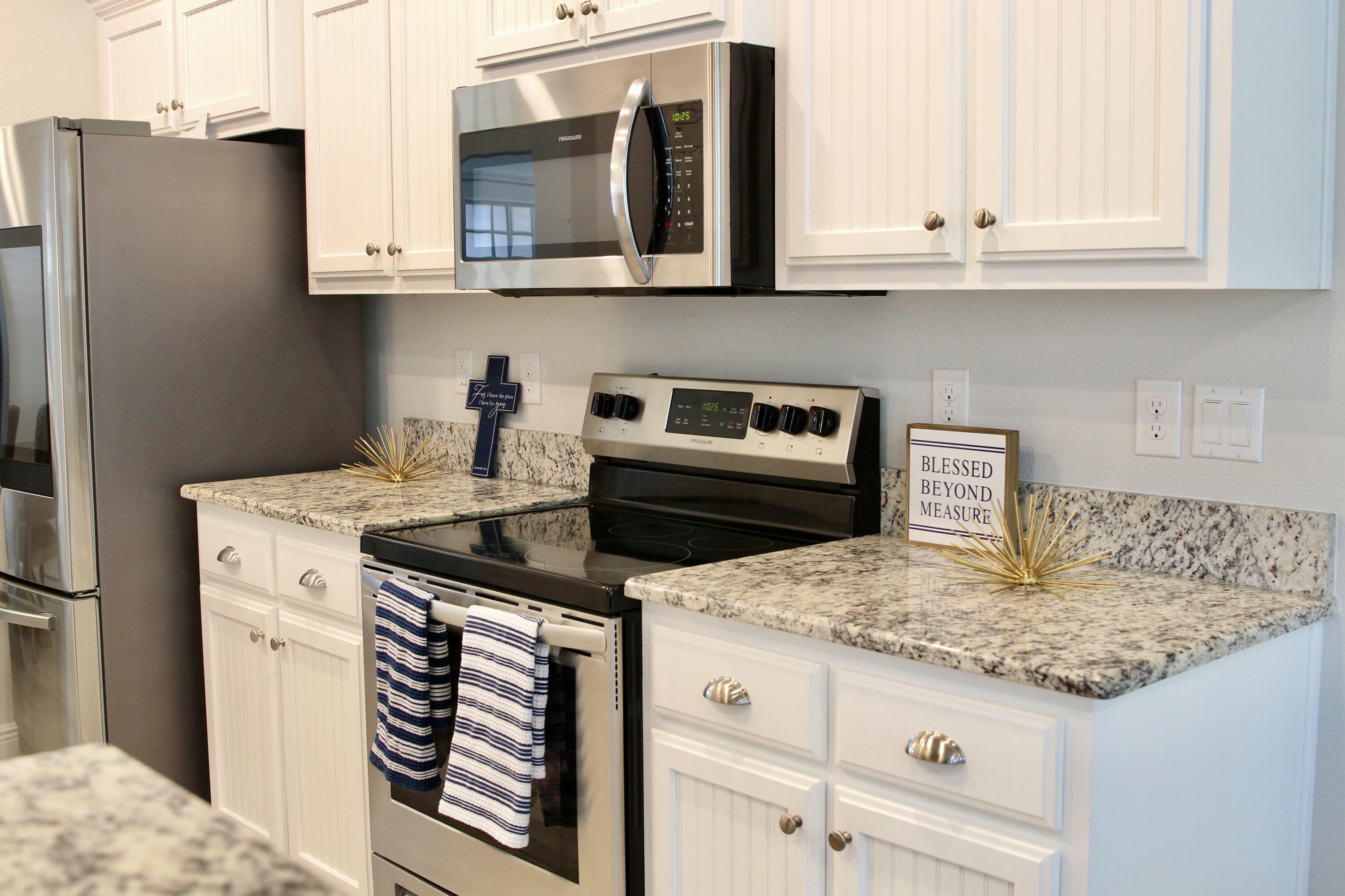 5755 Marigold Loop Crestview, FL 32539 - Photo 19 of 74 a kitchen with granite countertop a sink stove and microwave