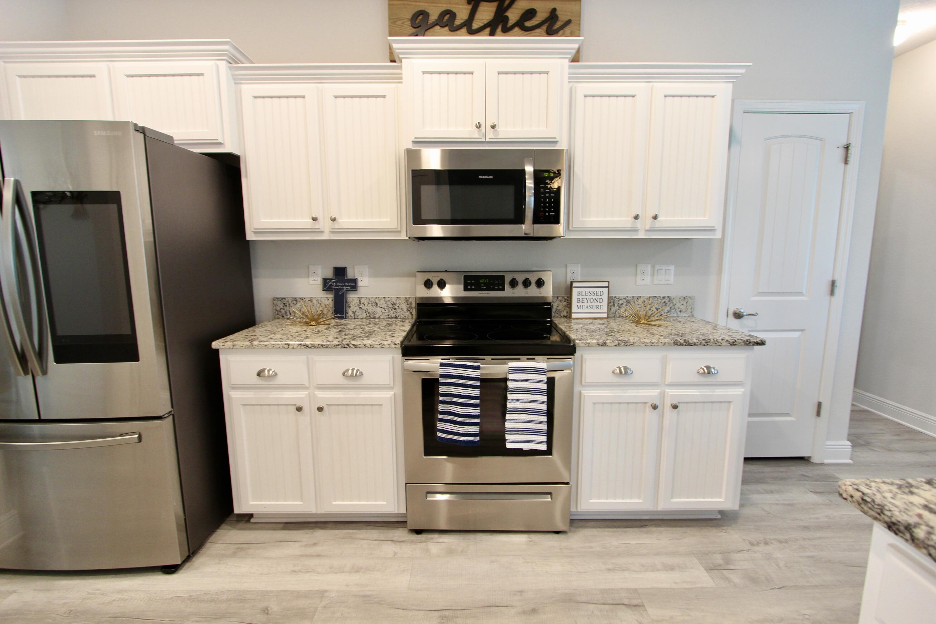 5755 Marigold Loop Crestview, FL 32539 - Photo 24 of 74 a kitchen with white cabinets and stainless steel appliances