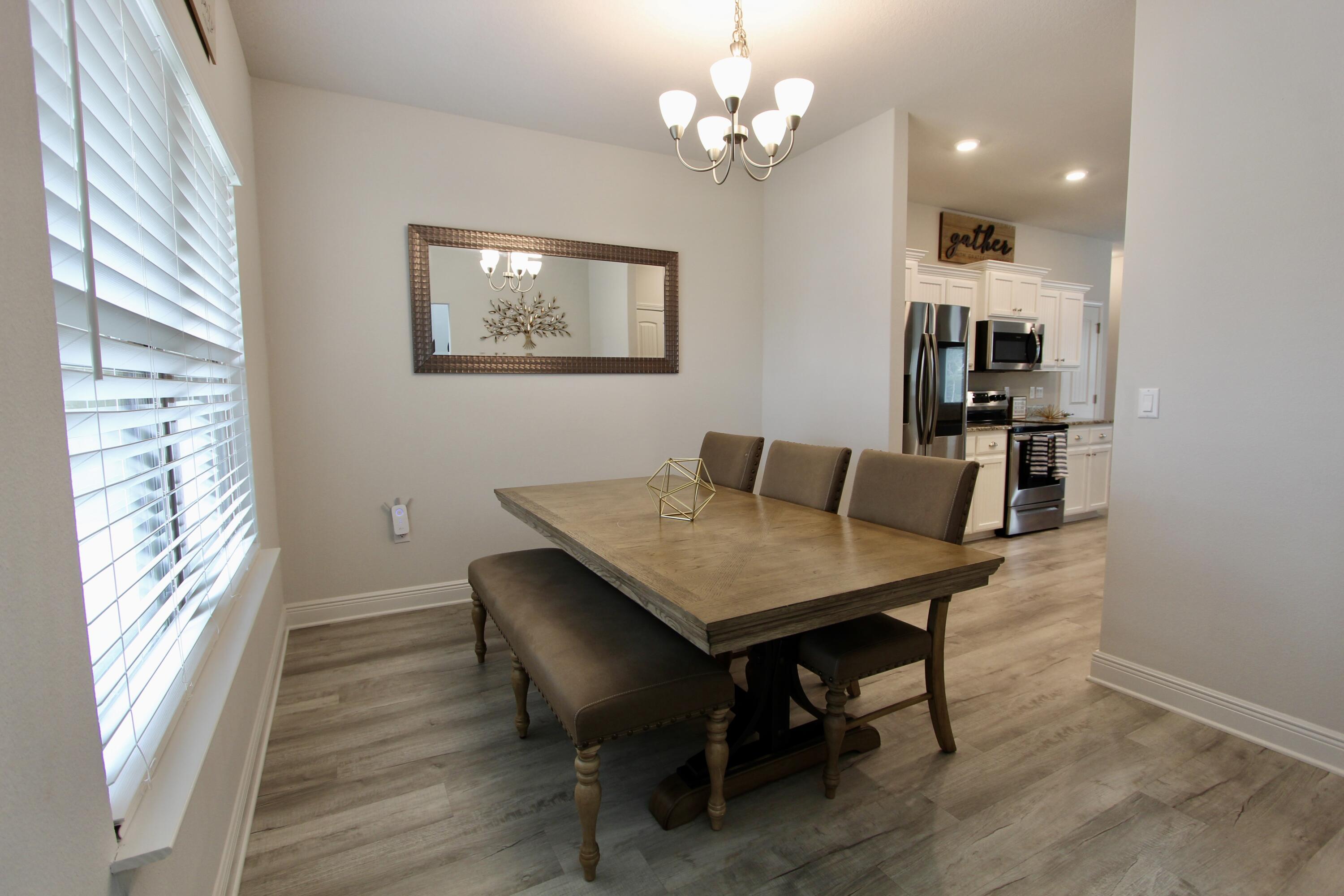5755 Marigold Loop Crestview, FL 32539 - Photo 28 of 74 a view of a dining room with furniture wooden floor and chandelier