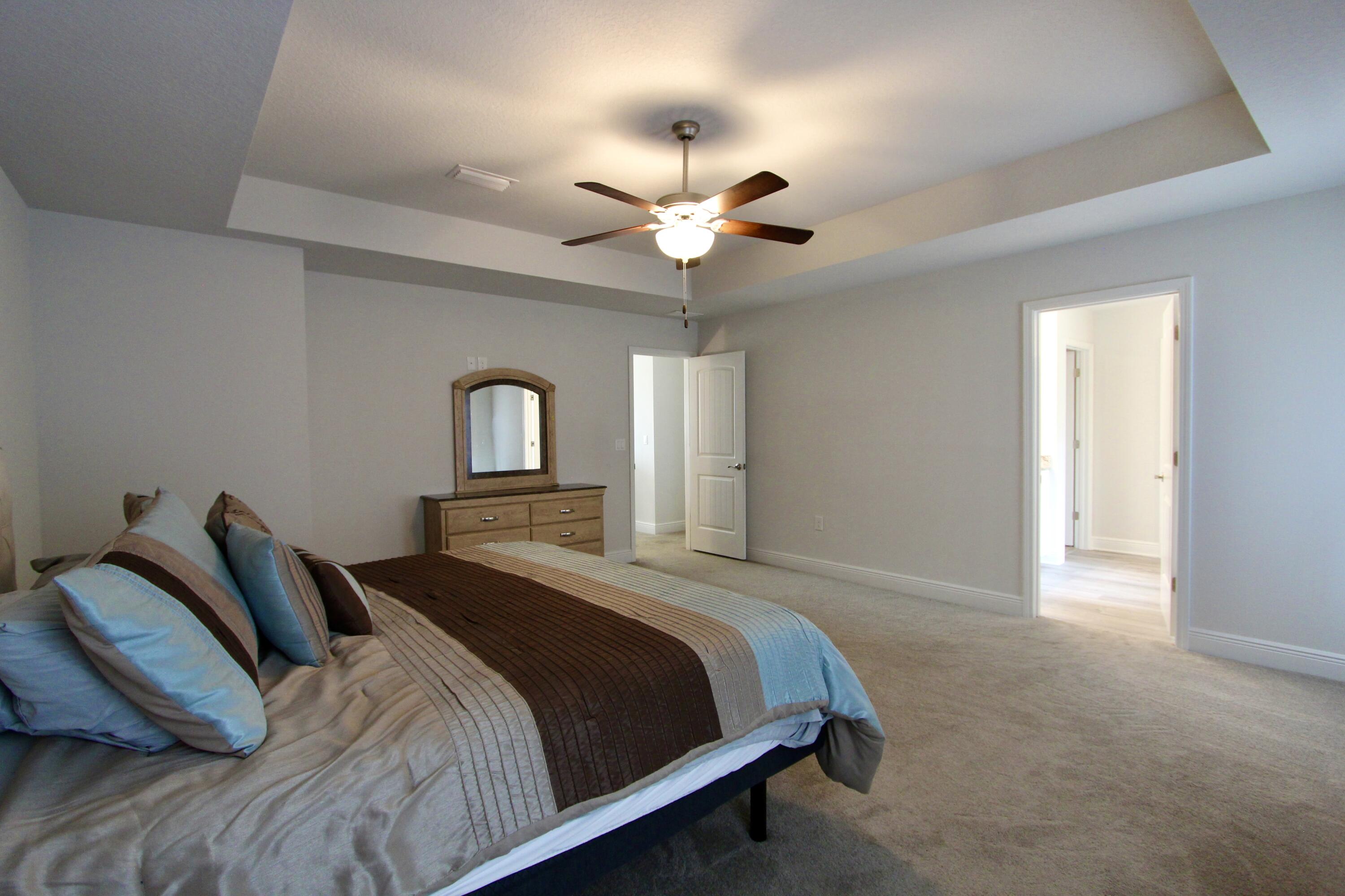 5755 Marigold Loop Crestview, FL 32539 - Photo 48 of 74 a bedroom with a bed and a chandelier