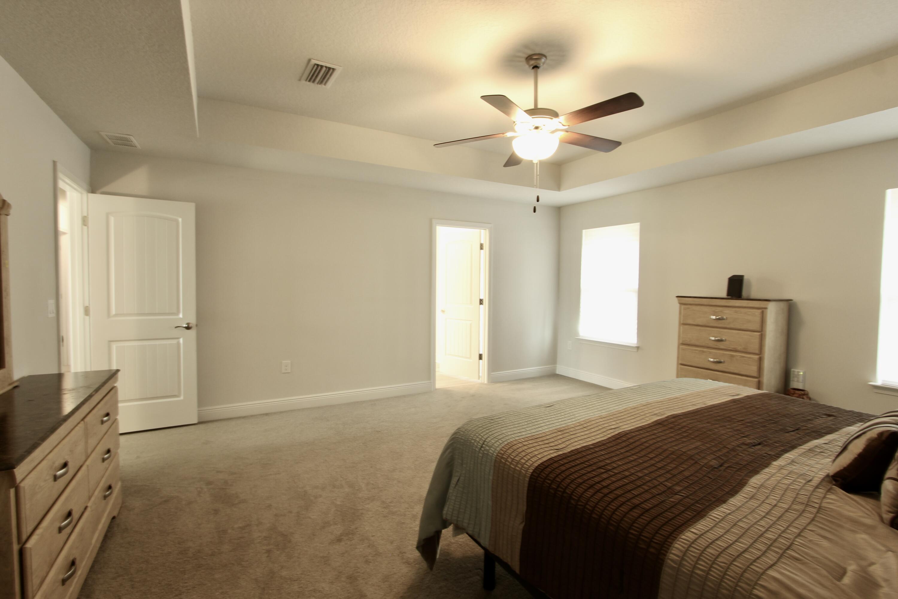 5755 Marigold Loop Crestview, FL 32539 - Photo 49 of 74 a bedroom with a bed and a chandelier
