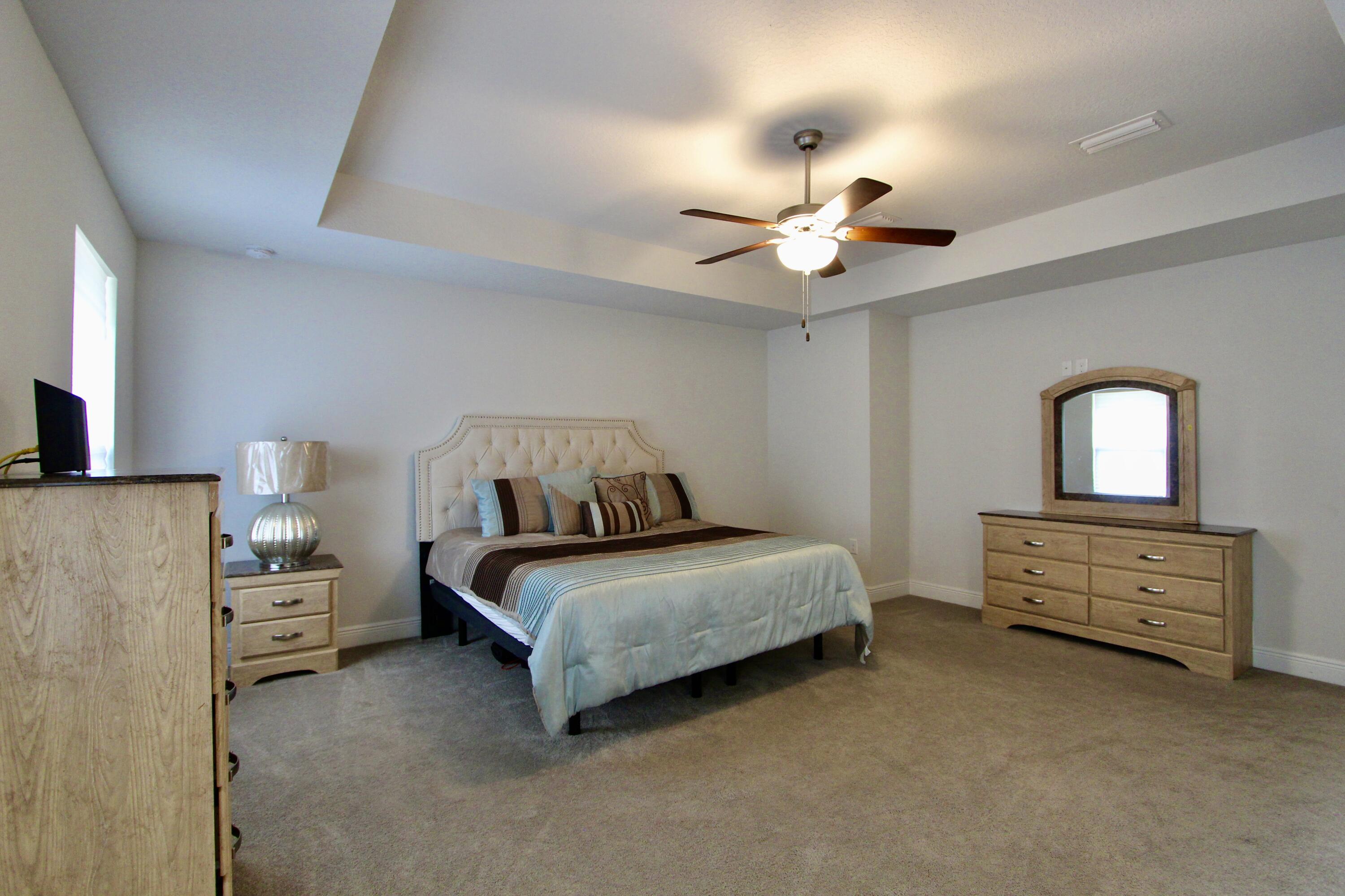 5755 Marigold Loop Crestview, FL 32539 - Photo 58 of 74 a bedroom with a bed and a chandelier