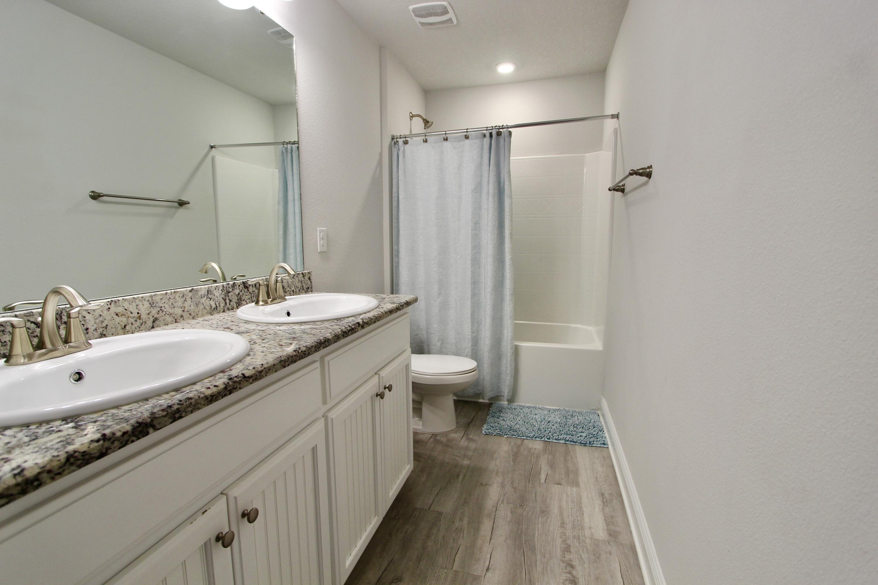 5755 Marigold Loop Crestview, FL 32539 - Photo 64 of 74 a bathroom with a granite countertop sink a toilet a shower and a mirror