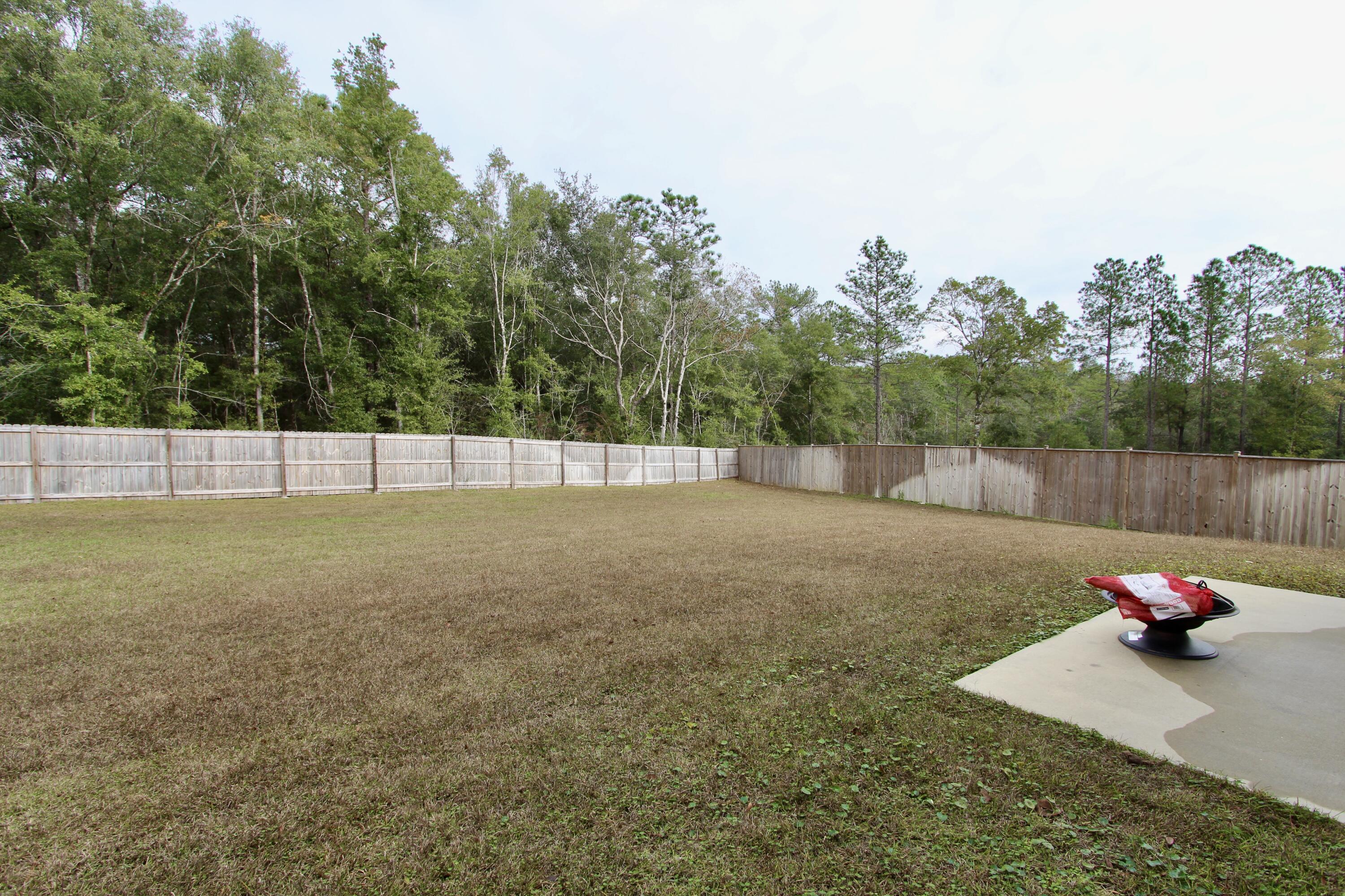 5755 Marigold Loop Crestview, FL 32539 - Photo 68 of 74 a backyard of a house with lots of green space