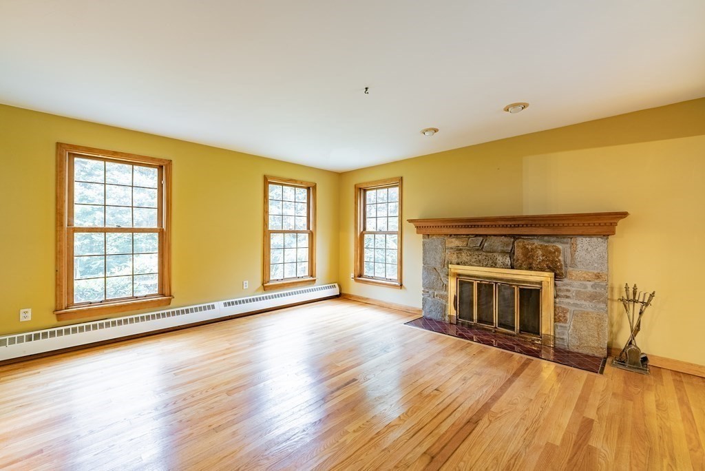 218 N Road Westhampton, MA 01027 - Photo 5 of 42 an empty room with wooden floor fireplace and windows