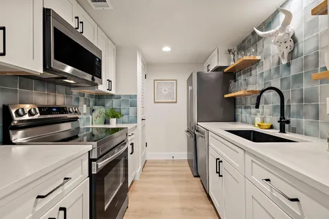 a kitchen with stainless steel appliances a sink a stove and a refrigerator