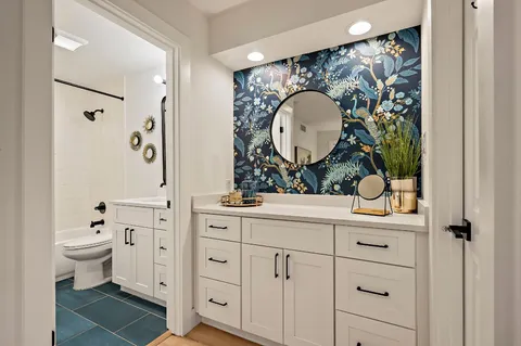 a bathroom with a toilet a sink and mirror