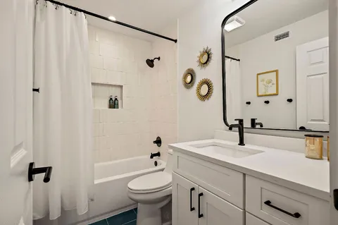 a bathroom with a sink a toilet and a mirror