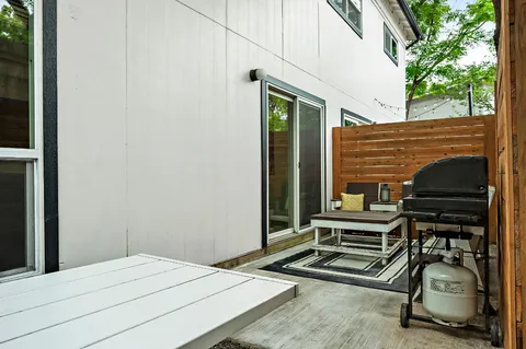 a backyard of a house with barbeque oven table and chairs