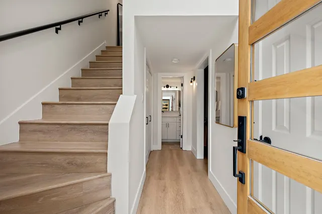 a view of a hallway with wooden floor and staircase