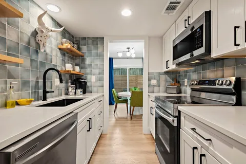 a kitchen with a sink and a stove top oven