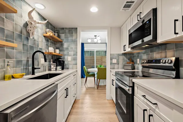 a kitchen with a sink and a stove top oven