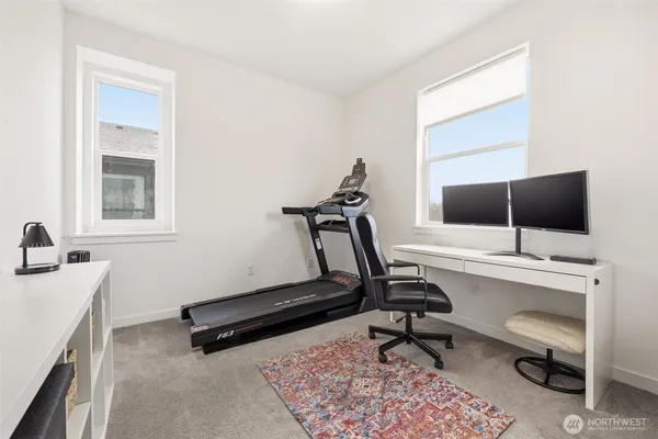 a view of a workspace with furniture and a window