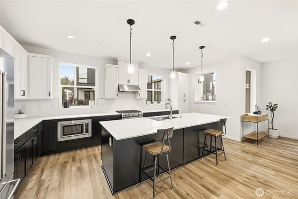 a kitchen with stainless steel appliances granite countertop a sink stove and wooden floor