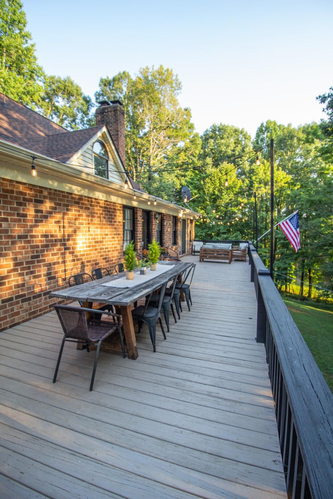 2420 Roaring Run Road Goode, VA 24556 - Photo 17 of 53 a view of a roof deck with table and chairs with wooden floor and fence
