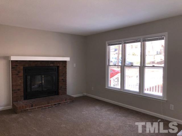 1121 Toppe Ridge Court Raleigh, NC 27615 - Photo 3 of 9 a living room with a fireplace and windows