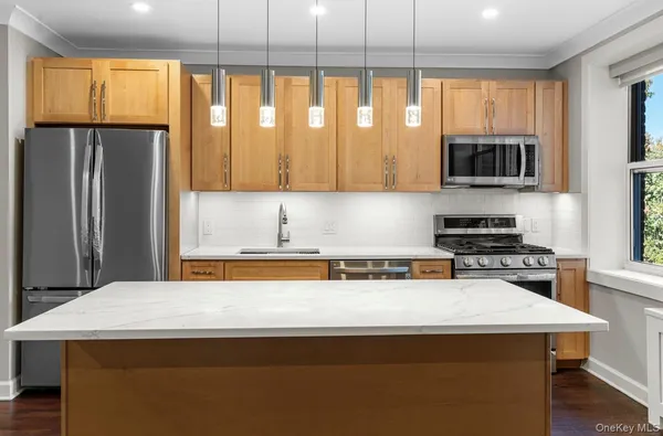a kitchen with stainless steel appliances granite countertop a stove a refrigerator and a microwave