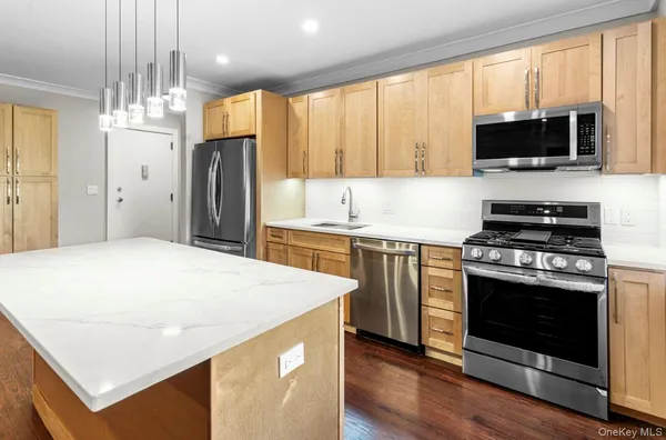 a kitchen with stainless steel appliances a stove a microwave and white cabinets