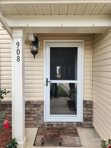 a view of front door and porch with wooden floor