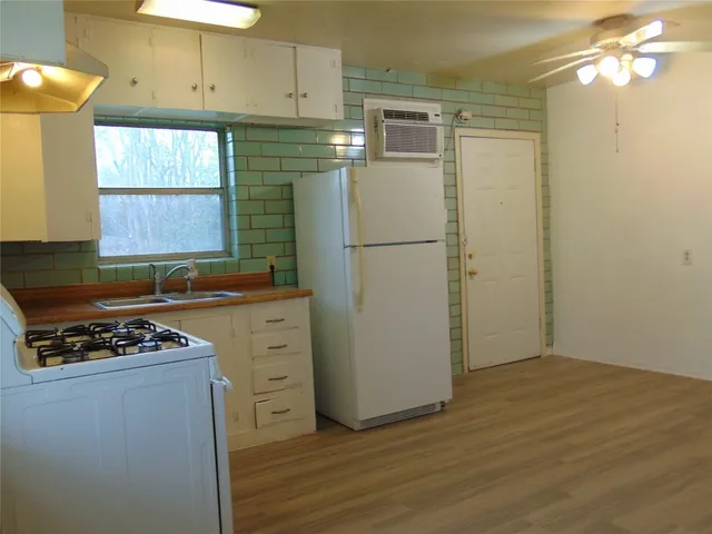 a kitchen with cabinets appliances a sink and a window